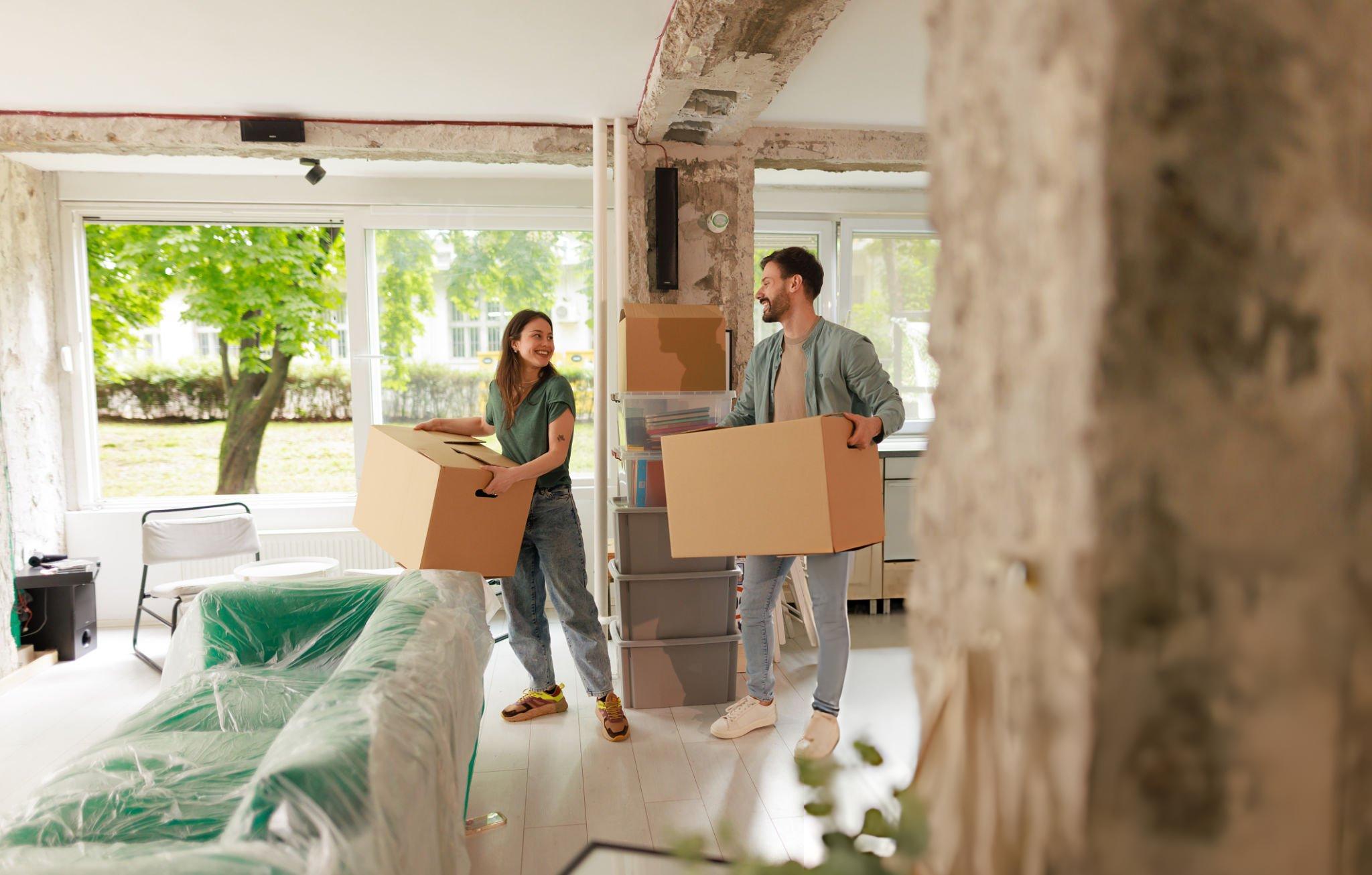 A happy couple carrying cartoons in their home